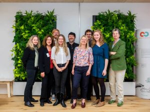 Beirat C2C NGO Gruppenfoto 9 Personen vor begrünter Wand