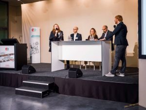 Bühne mit fünf Personen in Diskussion
