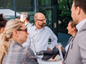 Gäste unterhalten sich an Stehtisch