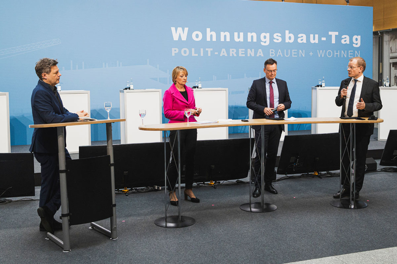 Robert Habeck (links) und drei weitere Personen stehen auf der Bühne und diskutieren.