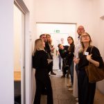 Mehrere Menschen stehen in einem Flur und schauen sich um