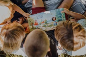 Kinder halten Kinderbuch in den Händen