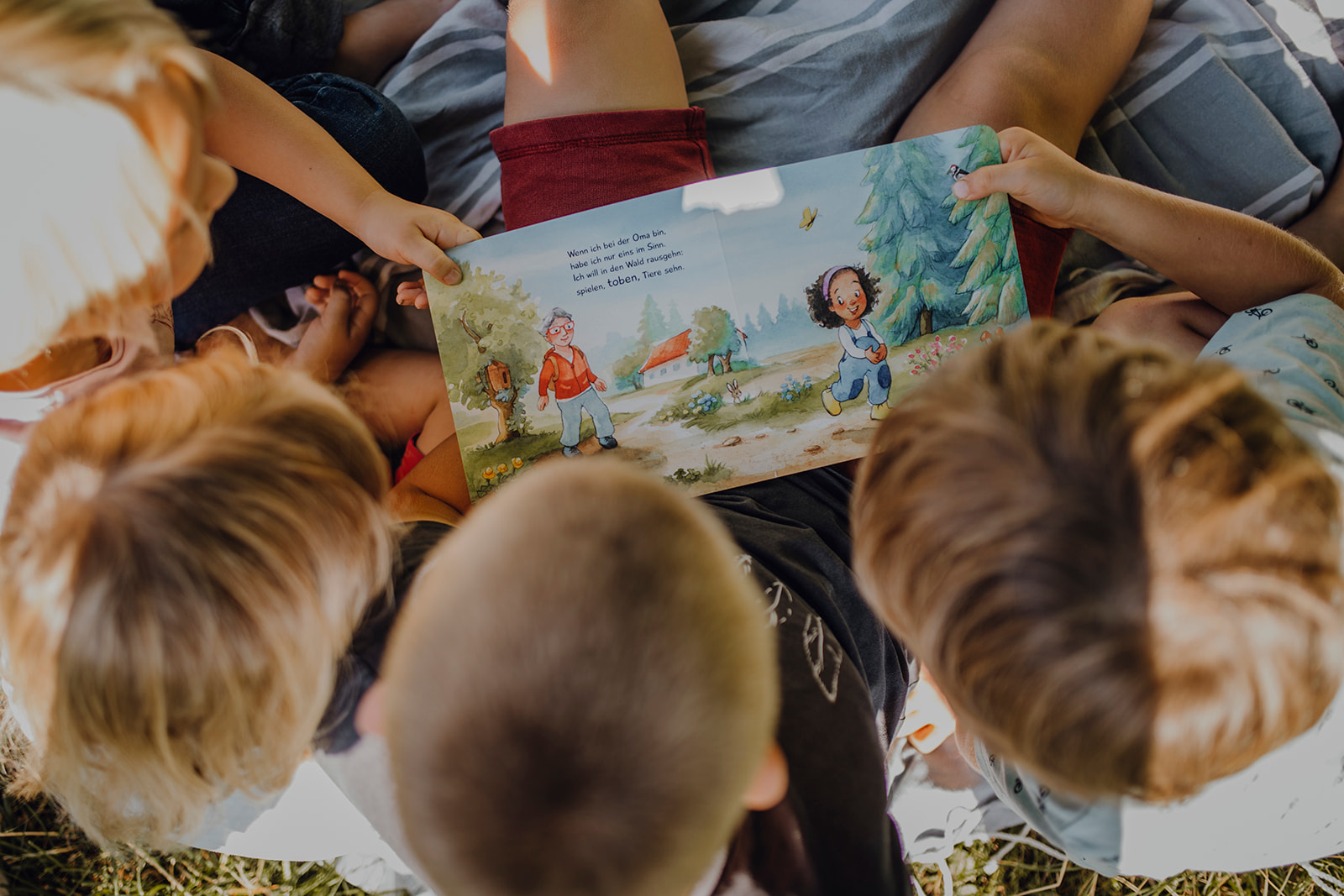 Kinder halten Kinderbuch in den Händen