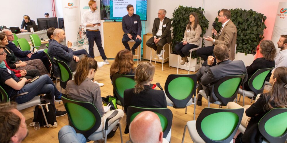 2022-C2C-Summit-Kommunen-der-Zukunft-gestalten-Panel-Kommunale-Bauprojekte_(vlnr.-Tim-Janßen,-C2C-NGO,-Manuel-Ehlers,-Triodos,-Vanja-Schneider,-Moringa,-Sybille-Mai,-EPEA,-Bernhard-Reger,-Leipfinger-Bader-©C2C-NGO