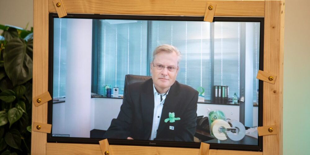 Ein Mann in einem Anzug wird auf einem Bildschirm gezeigt