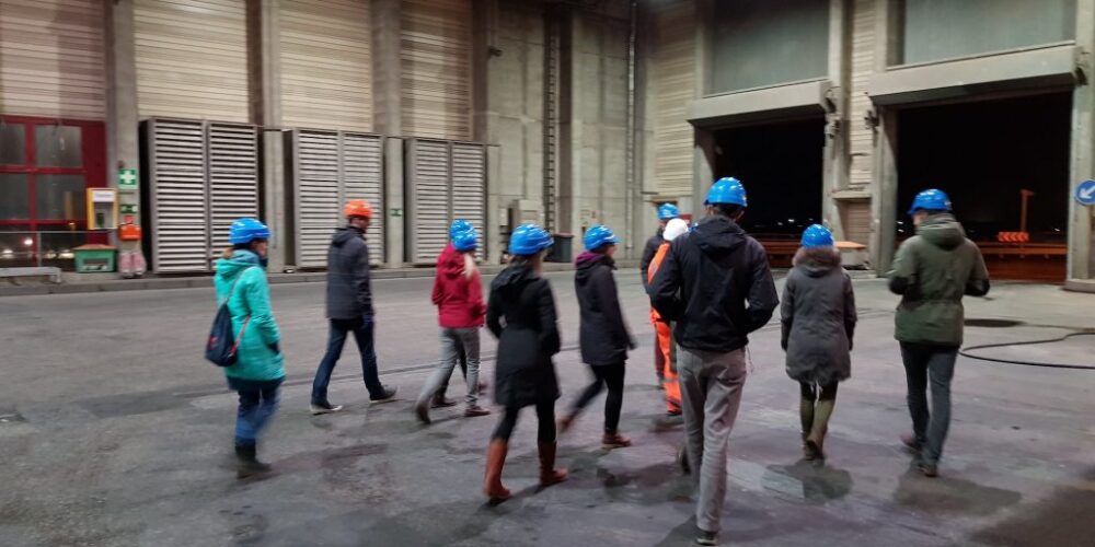 Gruppe mit blauen Helmen geht in Anlage rein