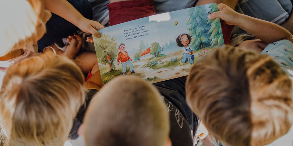 Kinder halten Kinderbuch in den Händen