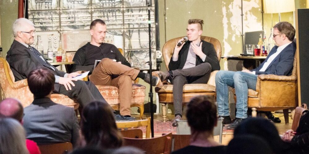 Podiumsdiskussion Abfall 4 weiße Männer auf Bühne sitzend