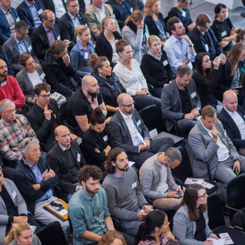 Event Summit, seated audience, many middle-aged white men in suits, photographed from above