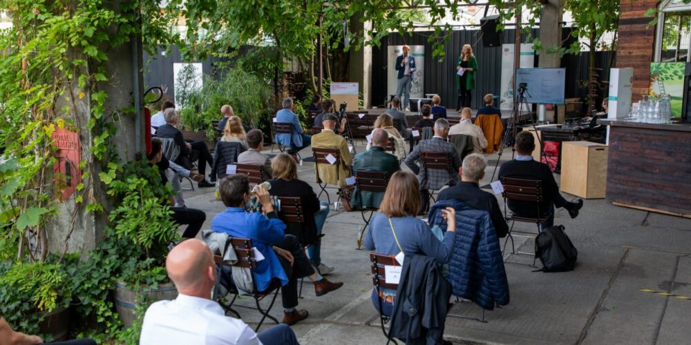 Menschen sitzen draußen vor Bühne auf Stühlen; Blog von Cradle to Cradle NGO
